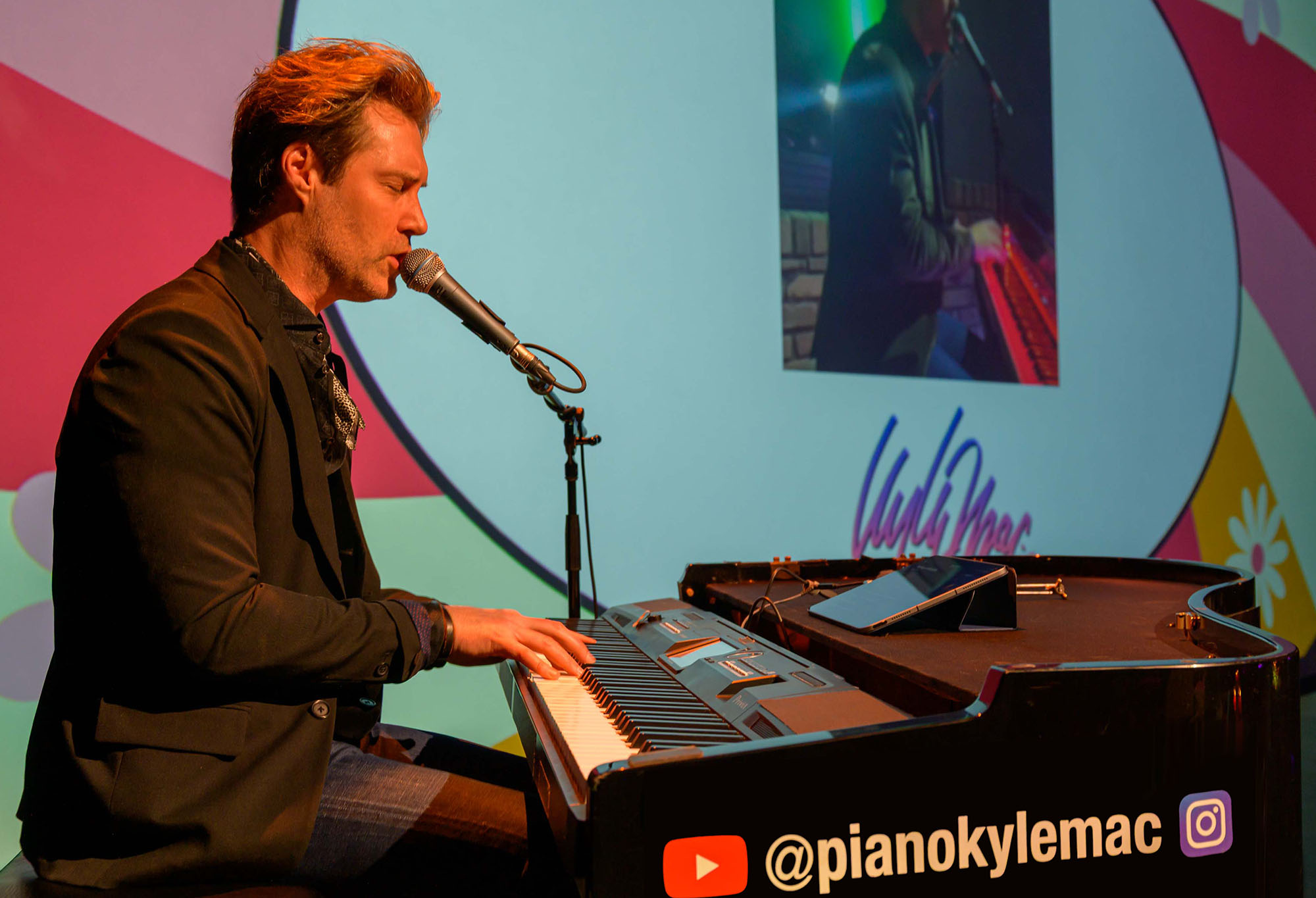 Piano player/singer performing on stage at a corporate event